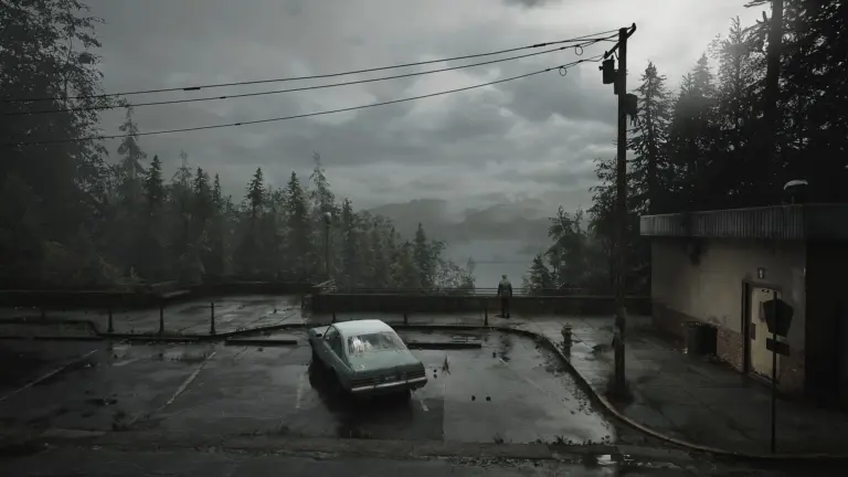 Ein nebliger Parkplatz in Silent Hill 2 mit einem Auto und einer einsamen Person unter einem grauen Himmel.