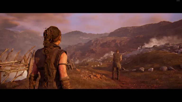 Ein Screenshot aus Senua's Saga: Hellblade 2 mit zwei Charakteren in einer bergigen Landschaft bei Sonnenuntergang.