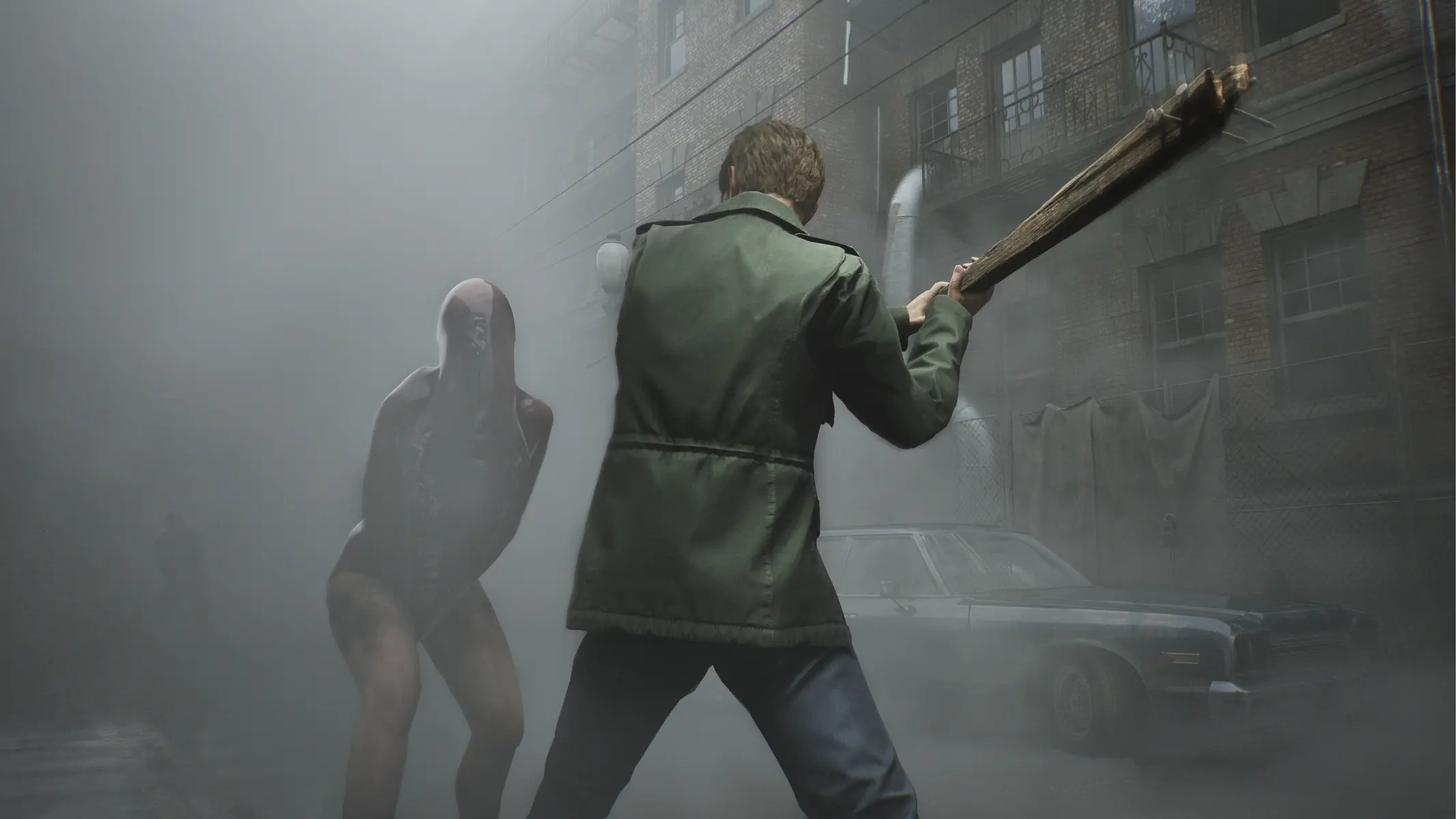 Ein Charakter aus dem Silent Hill 2 Remake steht mit einem Holzplanken bewaffnet einem Monster in einem nebligen Stadtviertel gegenüber.